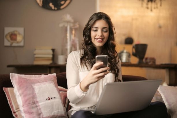 Femme consultant un site web responsive sur smartphone et ordinateur portable